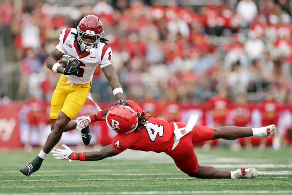 USC safety Christian Pierce, left, returns an interception past Rutgers...