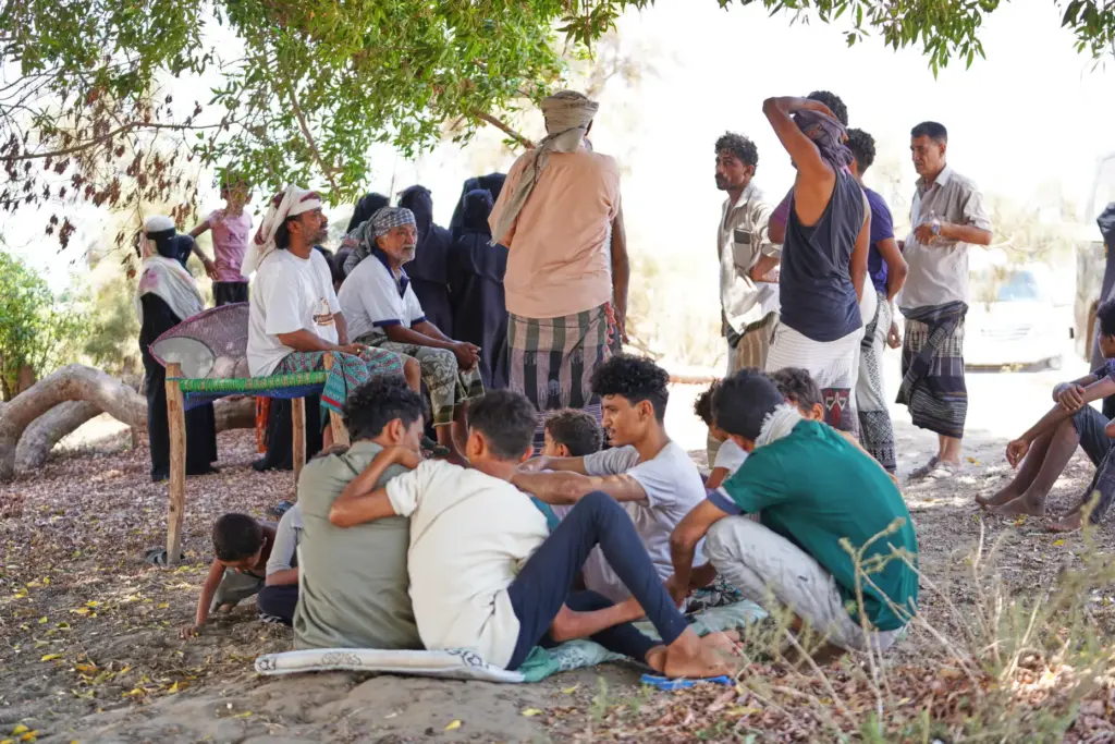 Displaced Yemenis wait to enter a temporary shelter in Aden, Yemen.