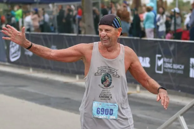 Legacy runner, Tom Frost, crosses the finish line at the...