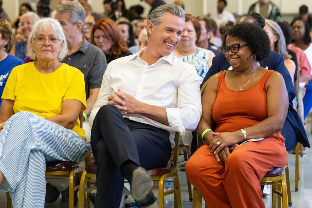 California Gov. Gavin Newsom shares a laugh with Dianne Kittrell,...