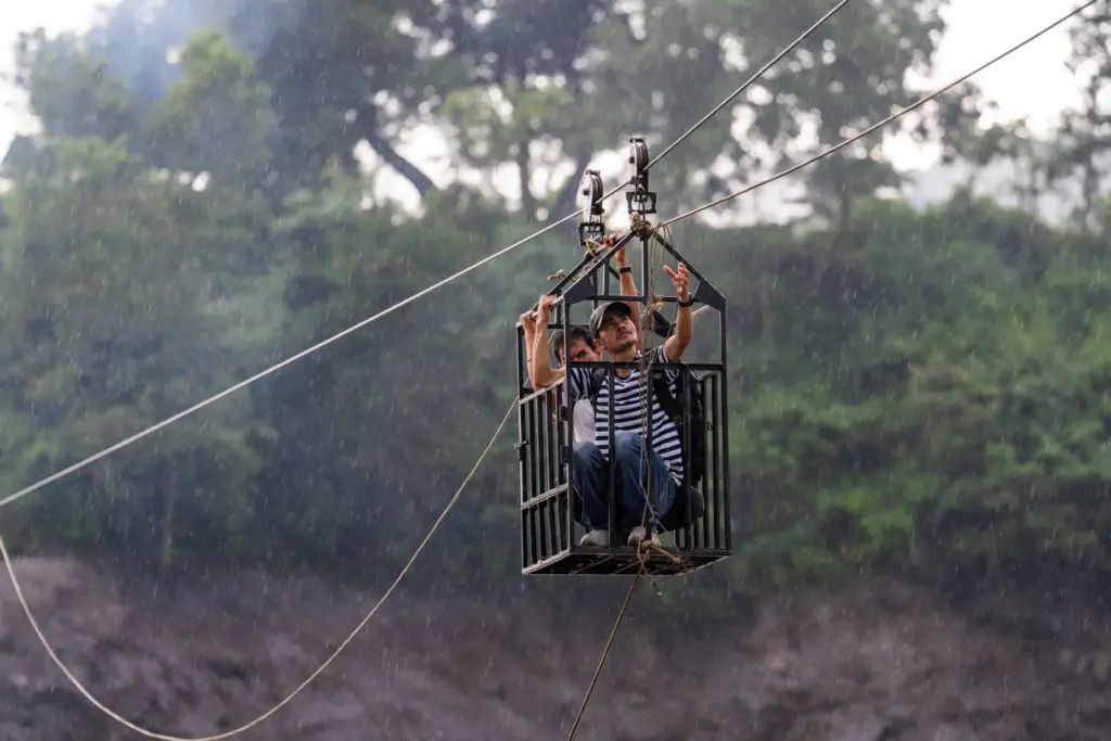Residents commute across the Trishuli river on a newly installed zipline.