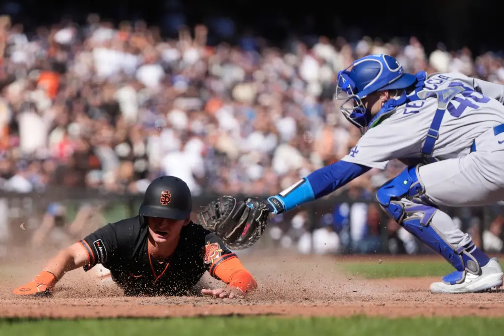 San Francisco Giants’ Turner Hill, left, slides home to score...