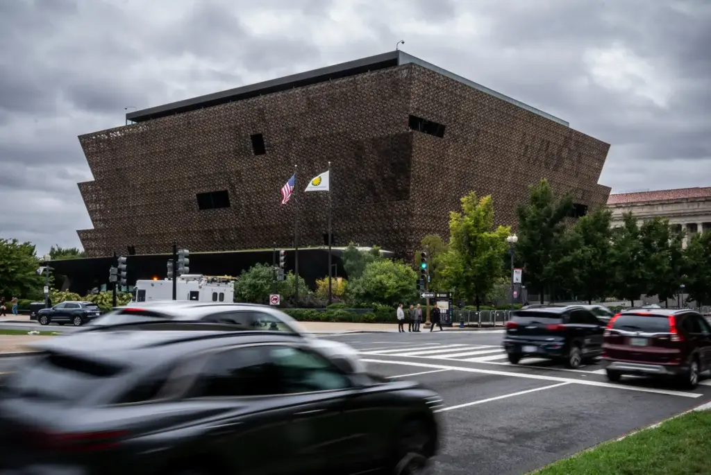 Cars drive past Smithsonian's National Museum of African American History and Culture.