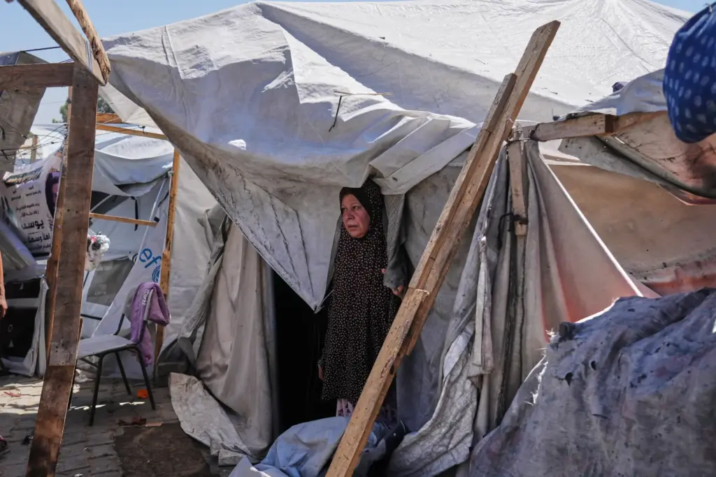 Palestinians inspect a destroyed tent following an Israeli army airstrike...