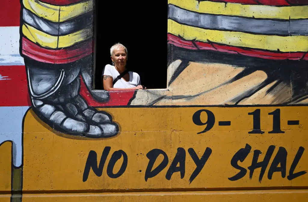 Muralist Rosie Tos in the burn tower that adorns her...