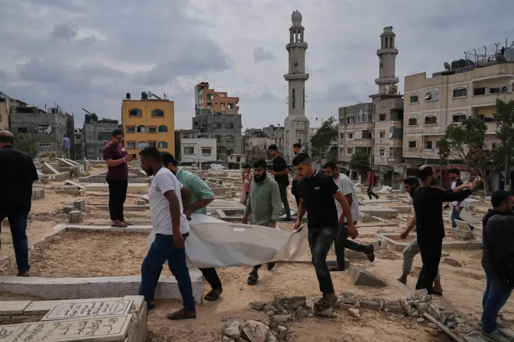 Mourners carry the remains of Palestinians killed in Israeli strikes.