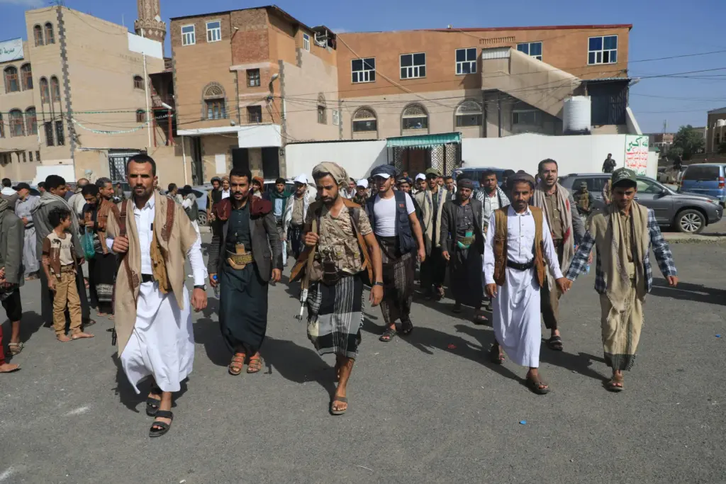 Yemen's Houthi rebels walk carrying weapons during a mobilization campaign in Sanaa, Yemen.