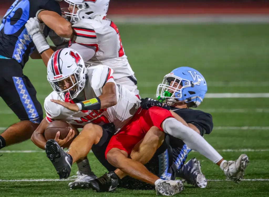 Lakewood quarterback Aidan Kautsky, left, is sacked by Villa Park...