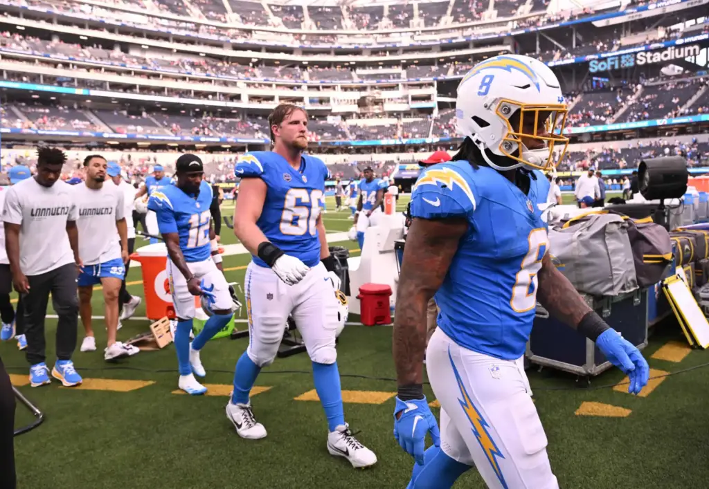 Chargers players walk off the field after a 26-14 loss...