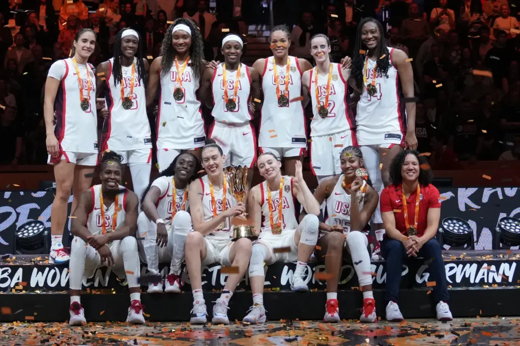 Team USA players and head coach Kara Lawson celebrate on...