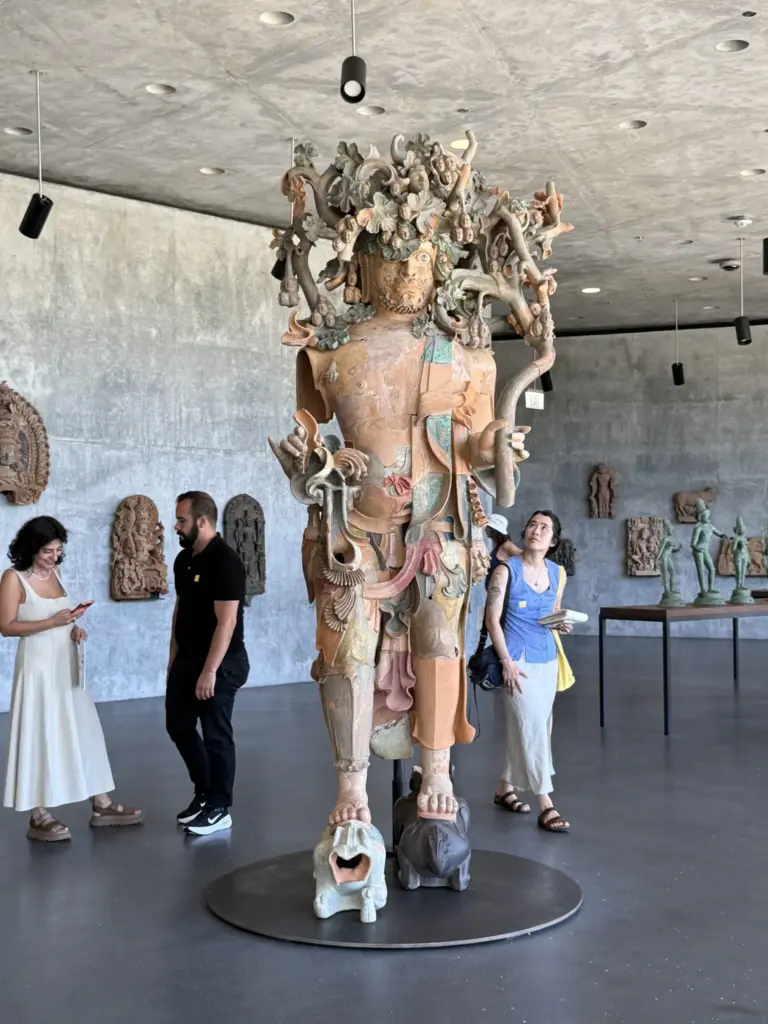 Museumgoers study a larger than life sculpture in the new...