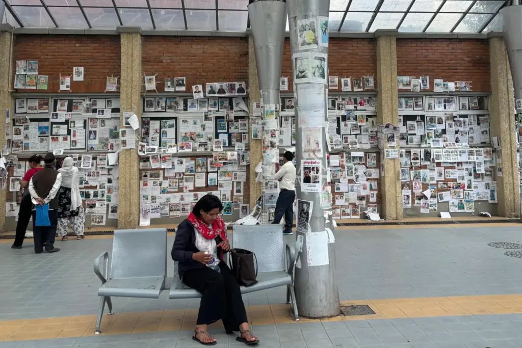 People look at photographs of hundreds of people missing.