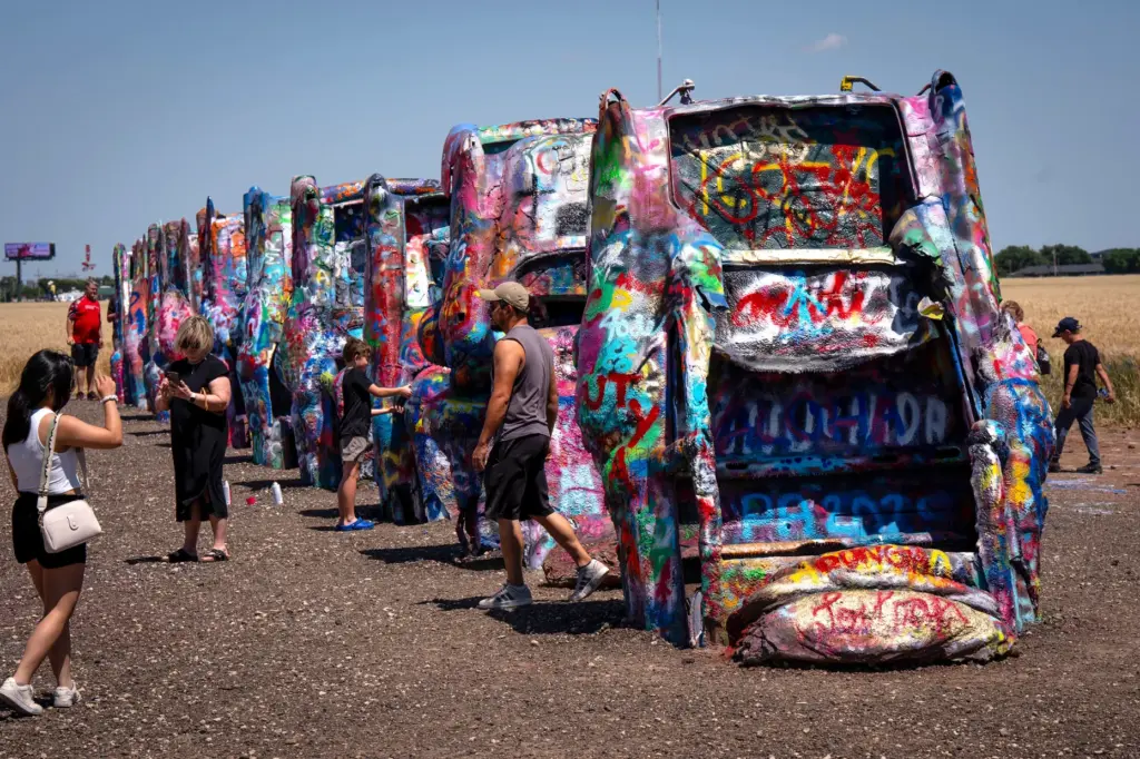 Route 66 tourists visit the Cadillac Ranch in Amarillo, Texas,...