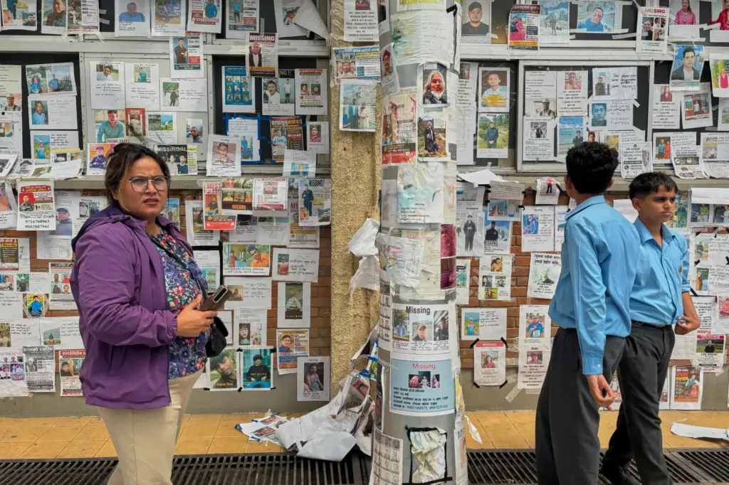 People look at photographs of hundreds of people missing since last month's floods.