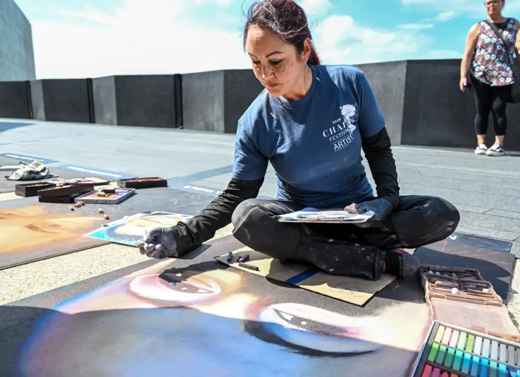 Chalk artist Jennifer Ripassa, from Eastvale, California, draws Nicole Carol...