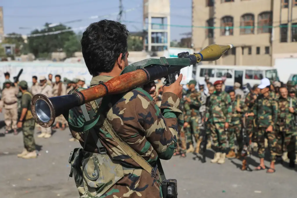 A fighter with Yemen’s Houthi rebels carries a rocket-propelled grenade...