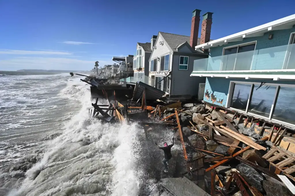 A worker tries to salvage part of a home that...