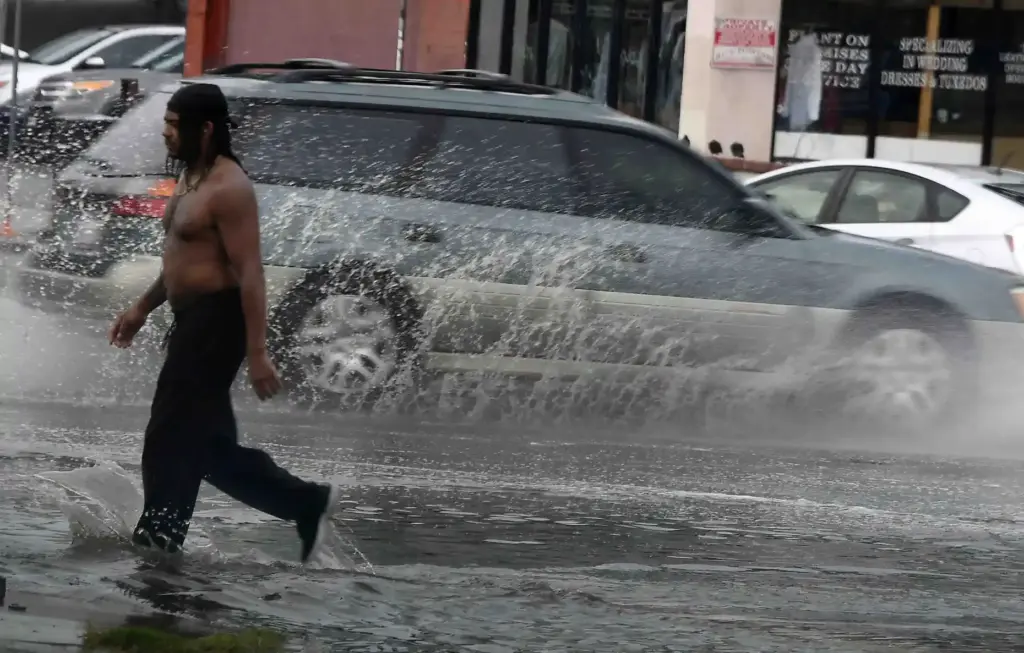A man walks through flooded intersection from Hurricane Marie Sunday,...