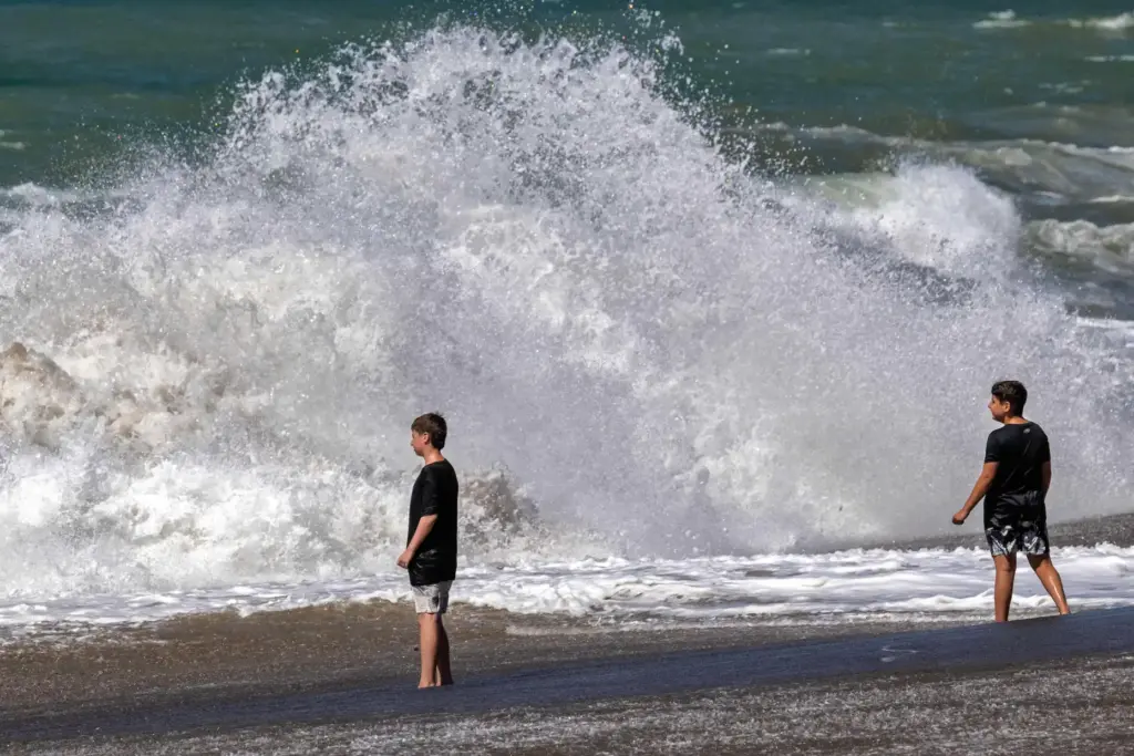 People watch large waves at Zuma Beach in Malibu, CA,...