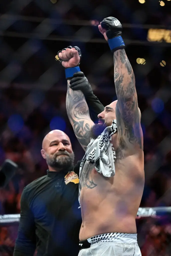 Sean Sharaf (blue) has his arm raised after knocking out...
