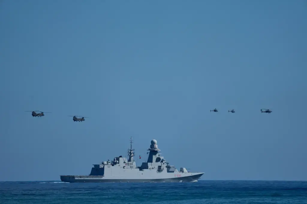 Military helicopters fly over the Italian Navy frigate Luigi Rizzo...