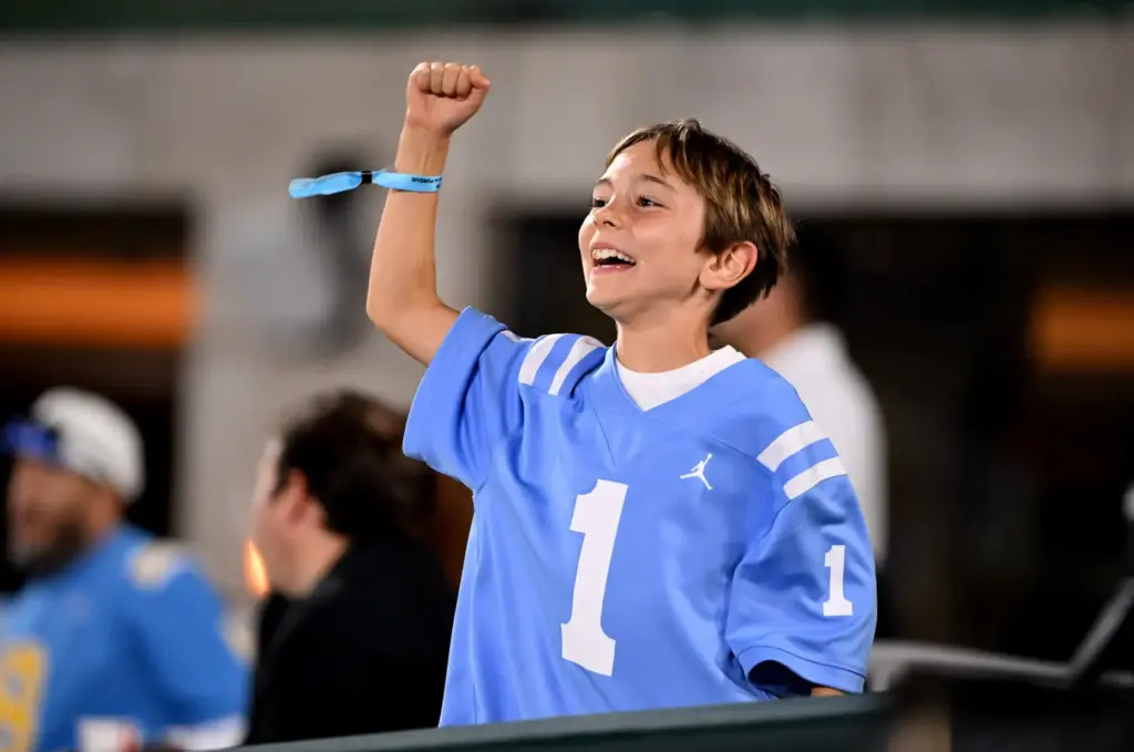 A young UCLA Bruins fan celebrates a touchdown against the...