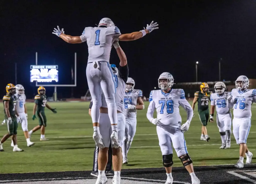 Corona del Mar players celebrate a touchdown by wide receiver...
