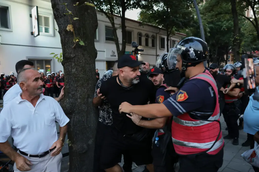 Police officers try to detain a protester during ongoing demonstrations...