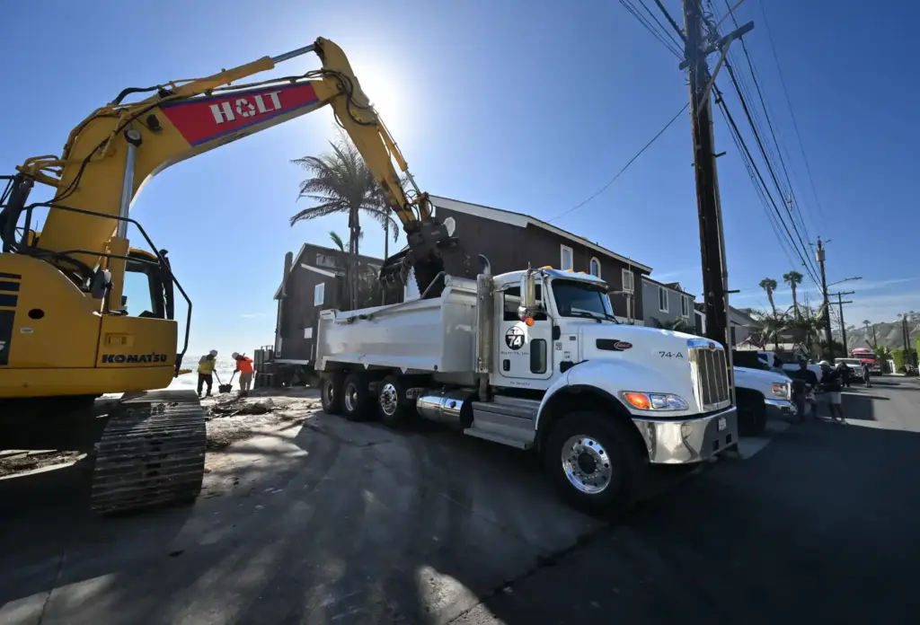 Worker clear a bulldozed home that was standing earlier that...