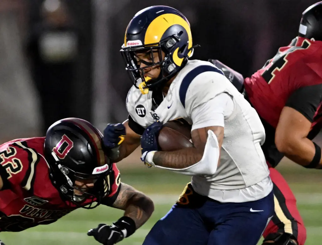Millikan’s Ryan Carter (7) runs for yards past Downey Vikings...
