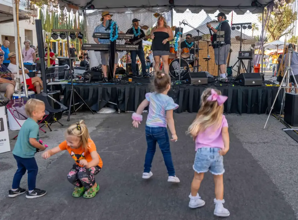 Kids dance in front of the Polynesian Street Stage, while...