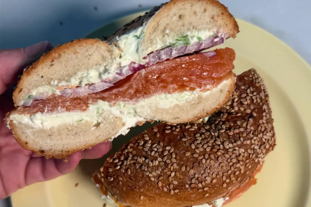 A bagel with smoked salmon, scallion cream cheese, and red...