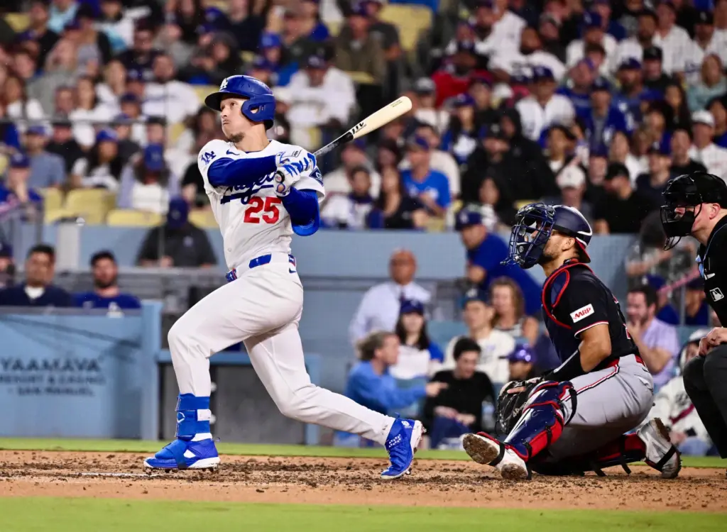 Dodgers center fielder Tommy Edman watches his RBI double as...