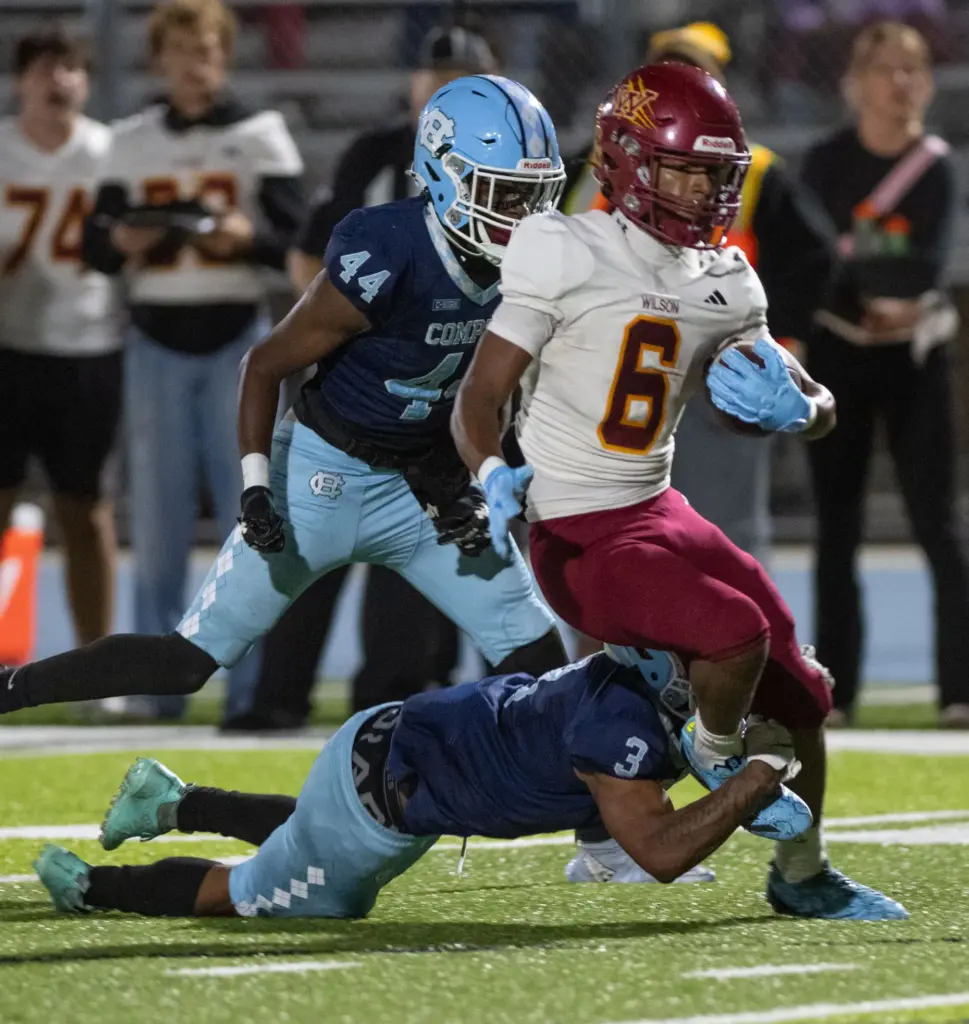 Compton’s Nathaniel Willard trips up Wilson’s Kyle Harris on a...