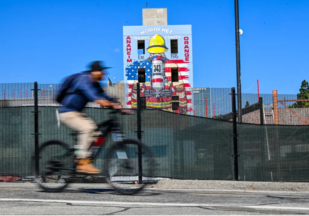 A cyclist rides past muralist Rosie Tosâ 9/11 firefighter mural...
