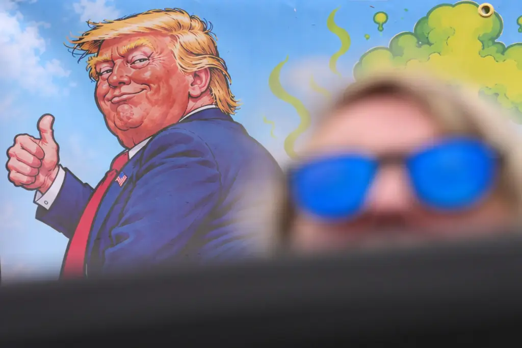 A protester wears sunglasses and sits in front of a...