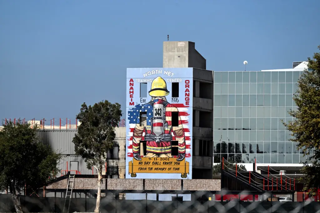 A cyclist rides past muralist Rosie Tosâ 9/11 firefighter mural...