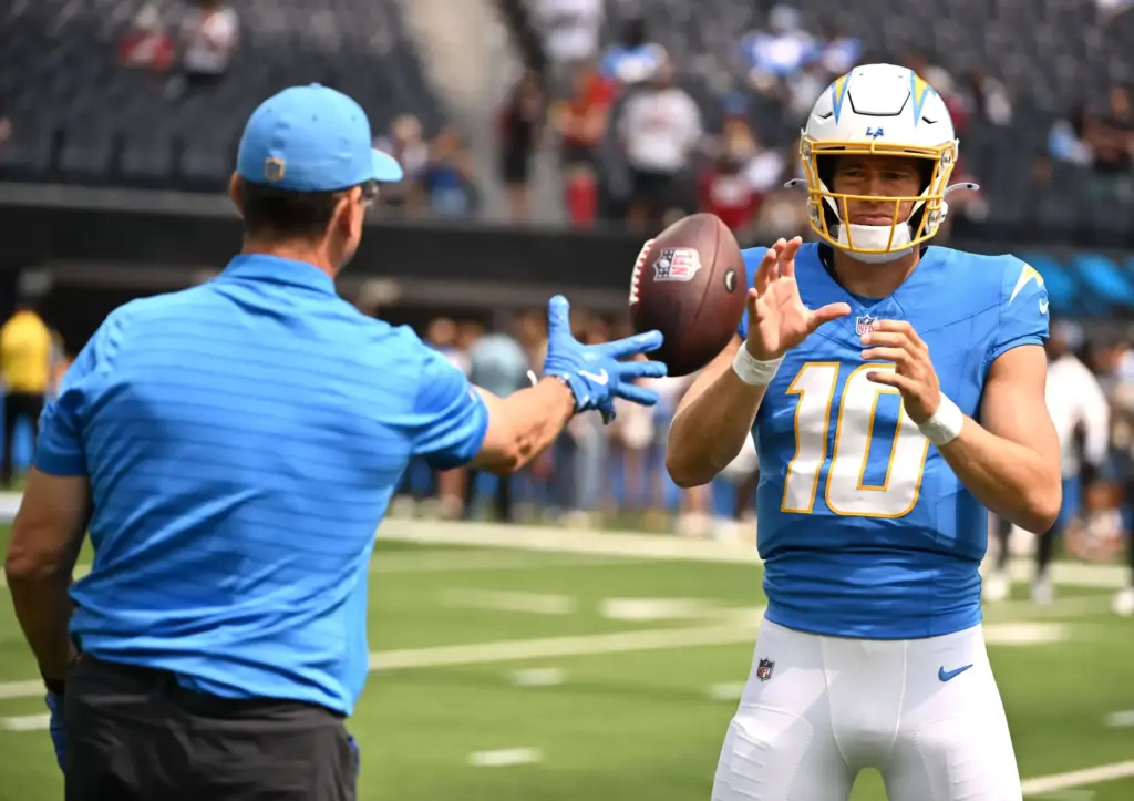 Chargers quarterback Justin Herbert (10) with head coach Jim Harbaugh...