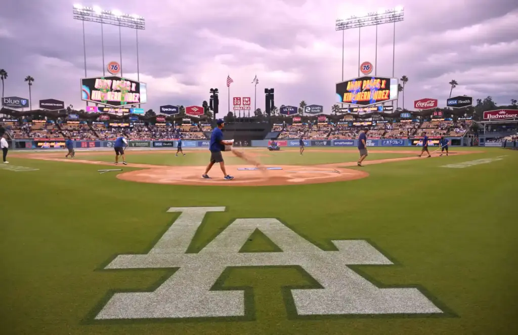 The Dodgers grounds crew works to prepare the field before...