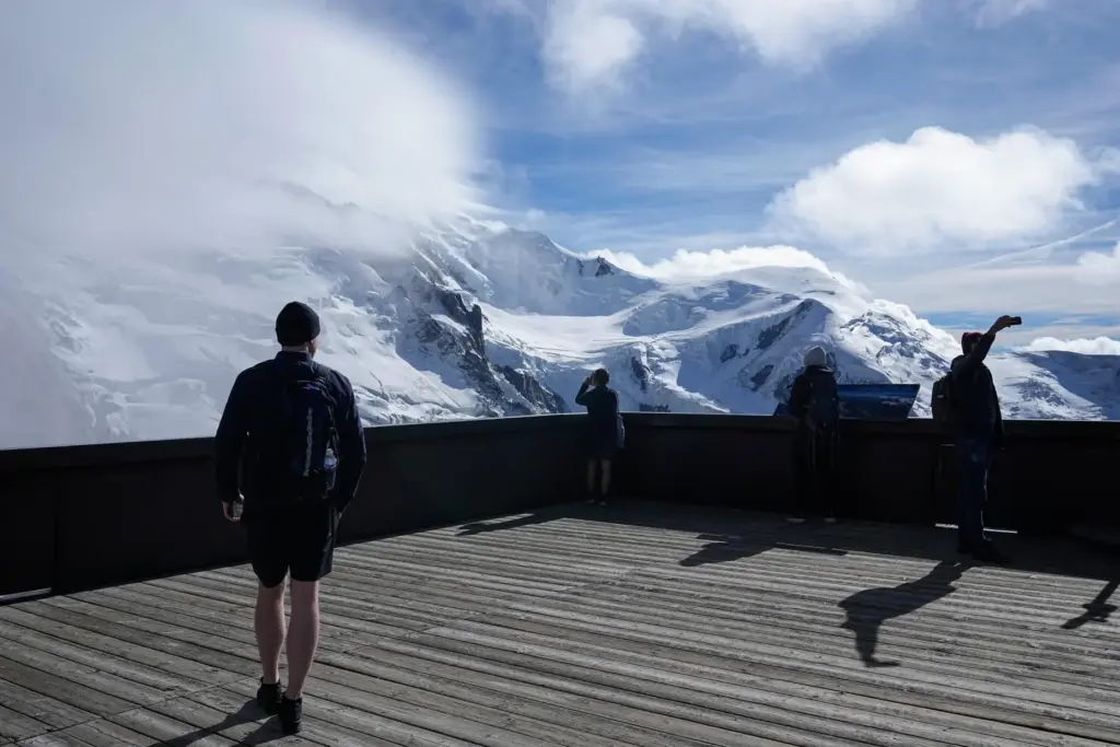 Tourists enjoy the view on the Mont-Blanc massif mountains.