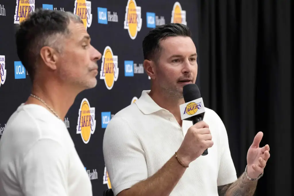 Lakers head coach JJ Redick, right, speaks to the media...