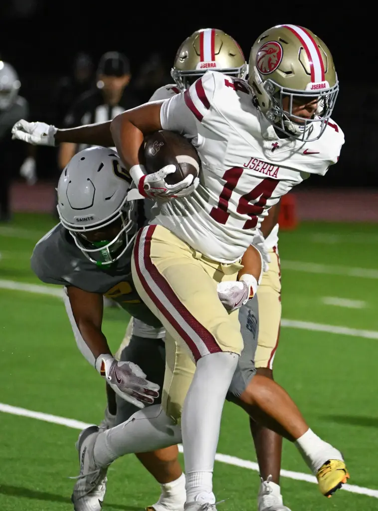 JSerra Kai Taylor (14) runs with the ball as Crean...