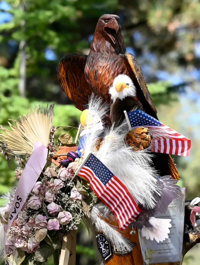A carved bald eagle sits atop a memorial prior to...