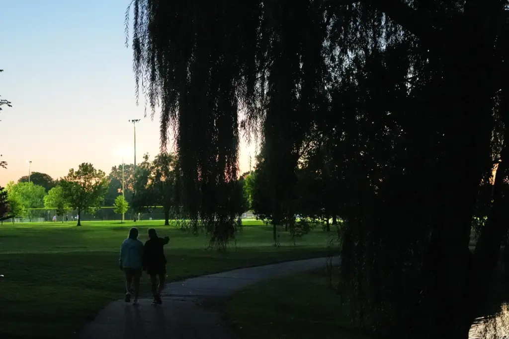 Kate Koubek and her wife, Deb Robertson, walk hand in hand at a park.
