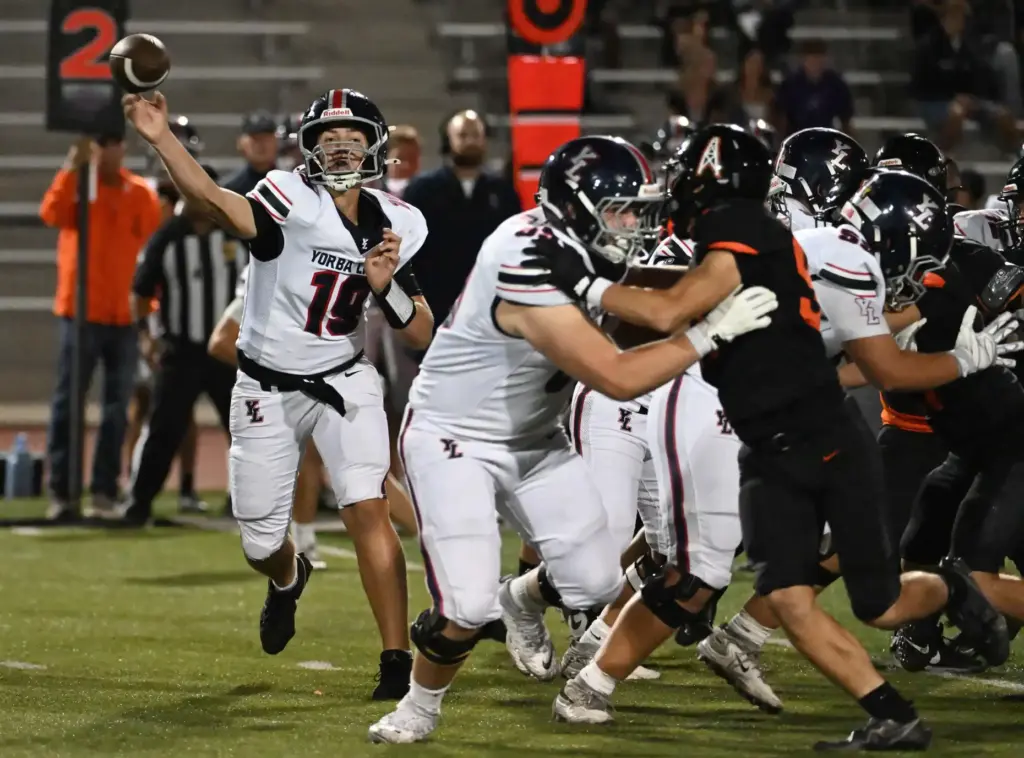 Yorba Lindaâs quarterback Andrew Churney (19) throws a completed pass...