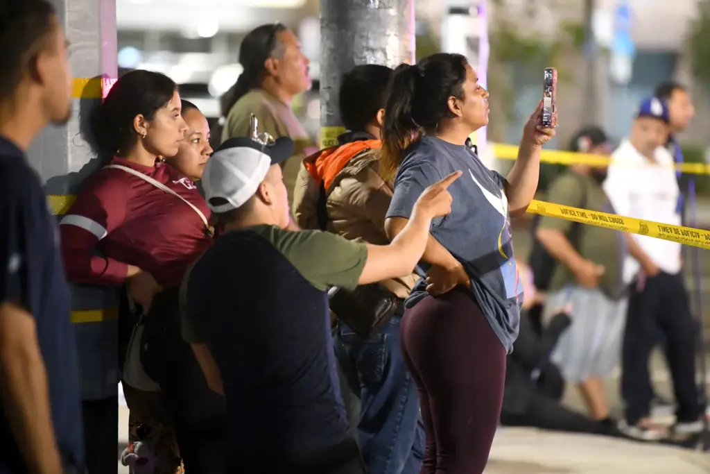 Onlookers gather at the scene of a collision between a...