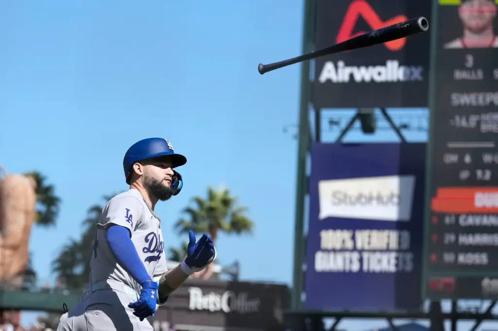 Dodgers’ Andy Pages throws his bat after hitting a three-run...