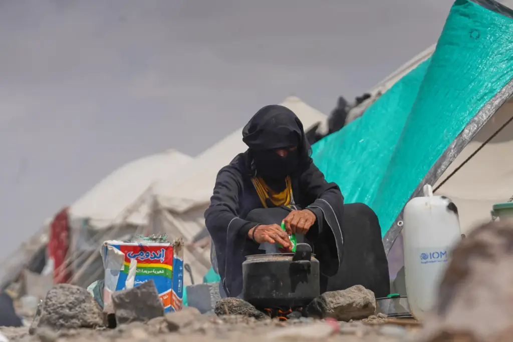 A displaced Yemeni cooks at Al-Firdaws camp in Ras Imran.