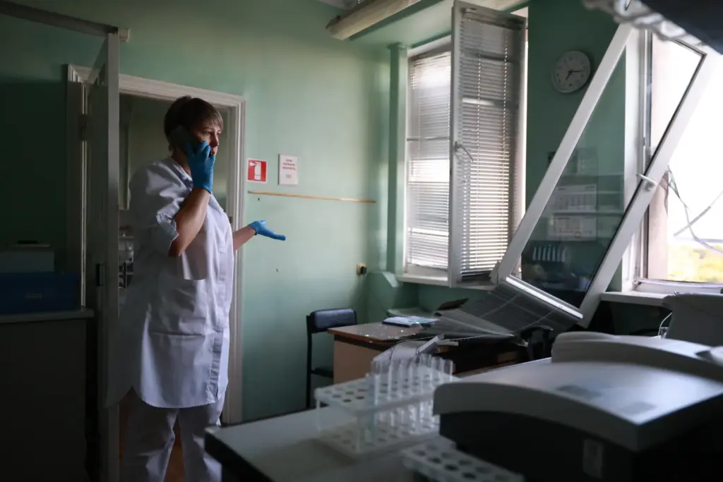 A medic speaks on the phone inside a hospital damaged...