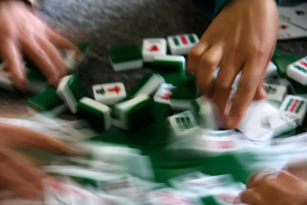 FILE – Mahjong tiles are shuffled during a game in...